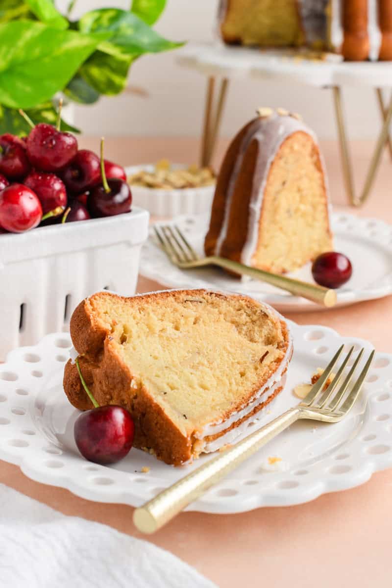 Amaretto Bundt Cake slice laying on plate with fork and second slice in the background.