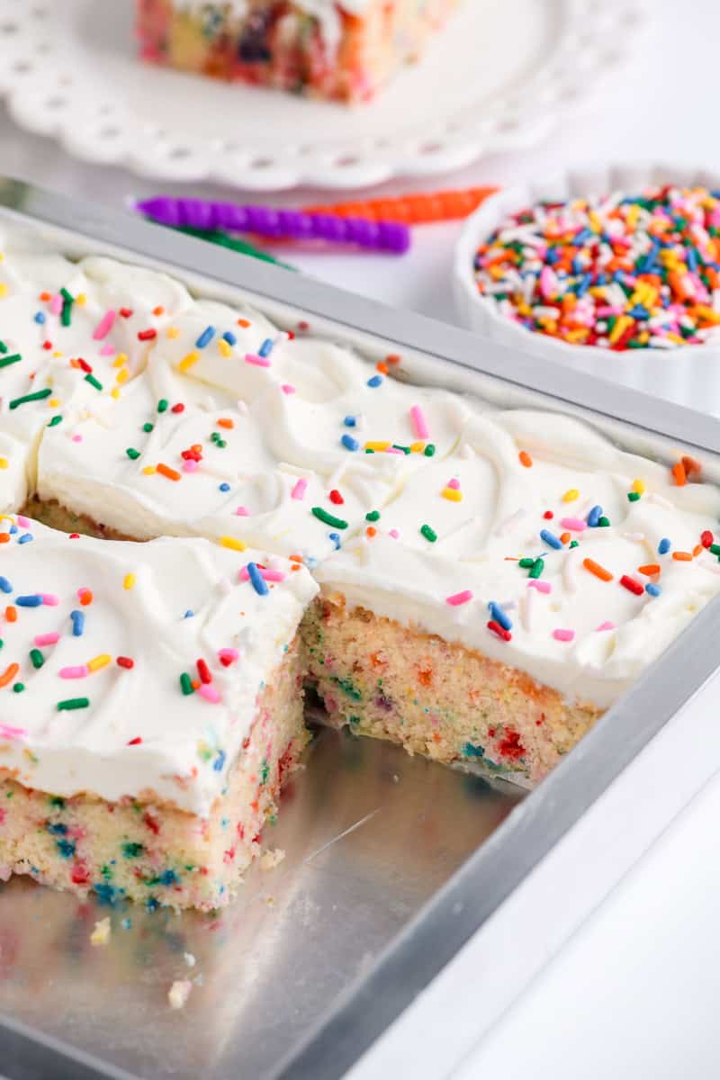 Angled shot of cut Funfetti Sheet Cake in baking pan.