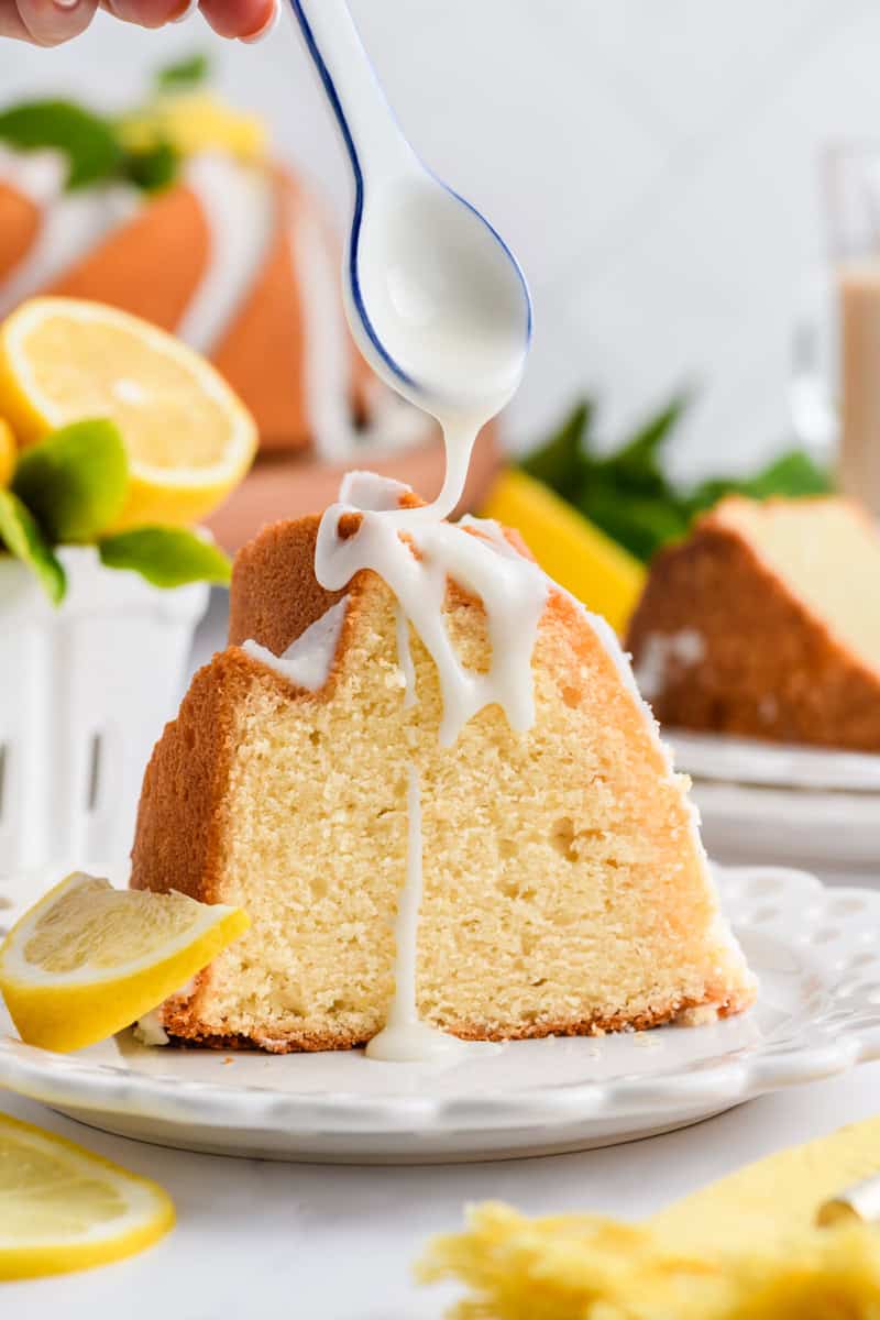 Close ups shot of slice of Lemon Bundt Cake with glaze being drizzled on top.