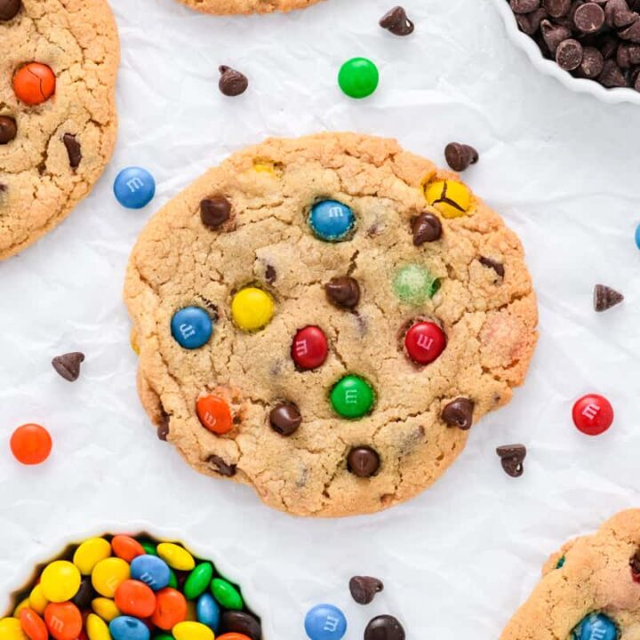 Overhead close up of single Best Big Fat Chewy Chocolate Chip M&M Cookie on wrinkled parchment paper.