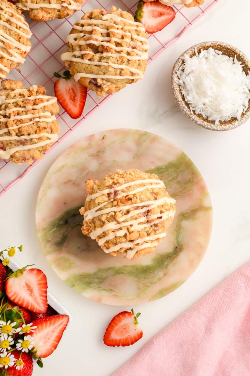 Overhead shot of single Homemade Strawberry Muffin on marble plate.