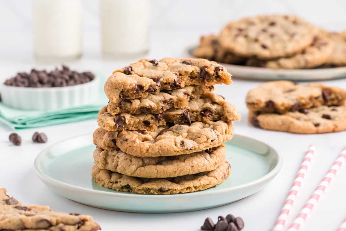 Wide open shot of a stack of broken Best Big Fat Chewy Chocolate Chip Cookies on teal plate.
