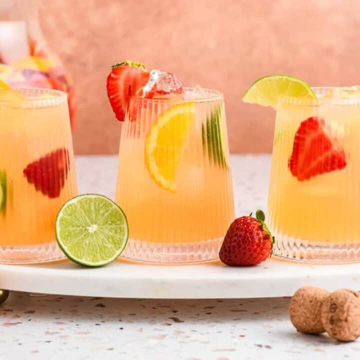 Head on shot of 3 glasses of Sparkling Sangria on marble serving tray.