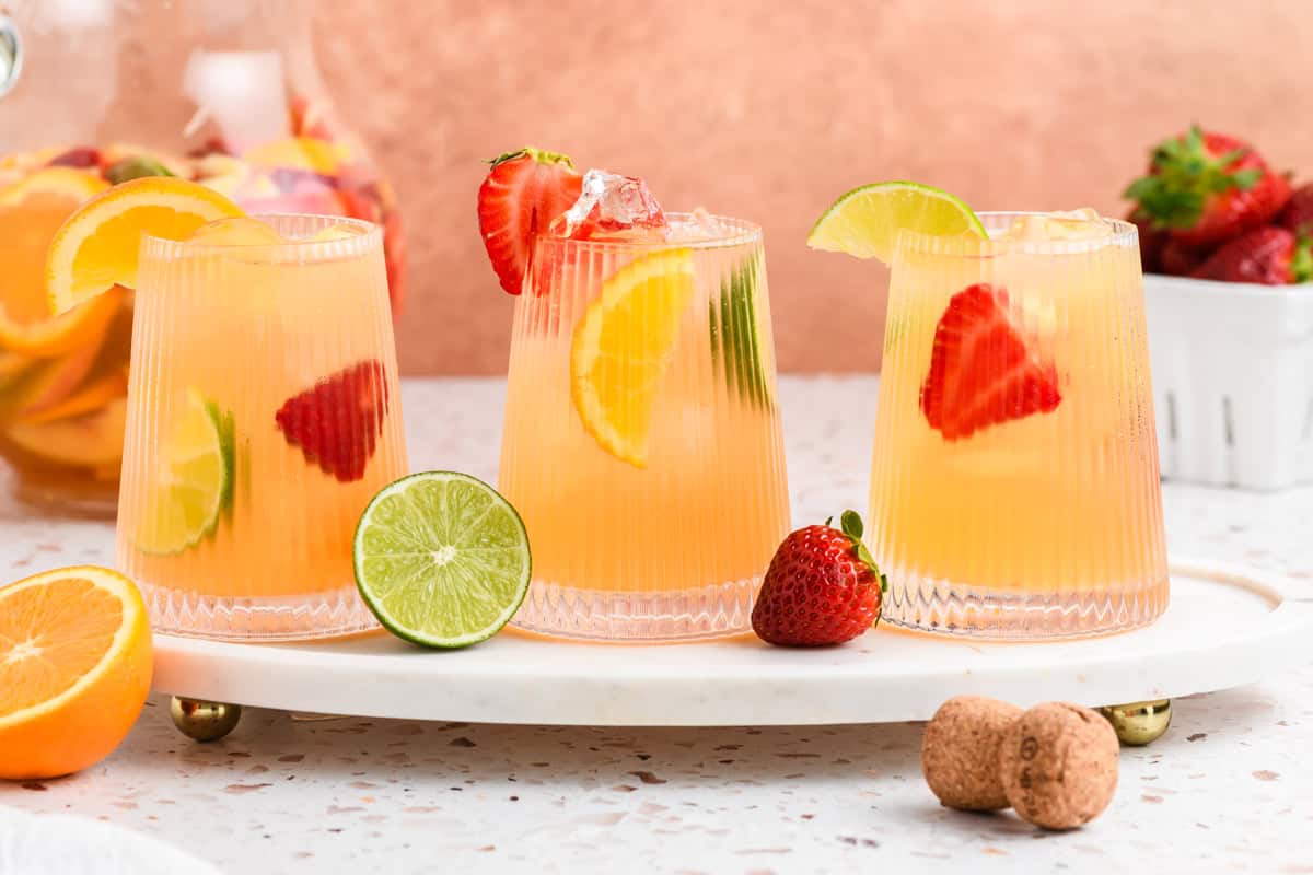 Head on shot of 3 glasses of Sparkling Sangria on marble serving tray.