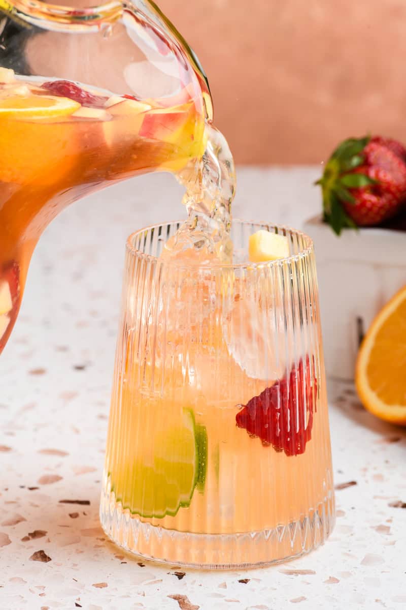 Sparkling Sangria being poured into a glass.