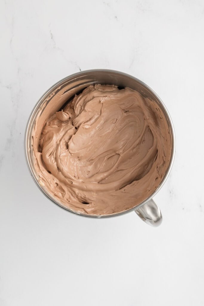 Overhead shot of completed chocolate Swiss meringue buttercream for M&M Chocolate Cake.
