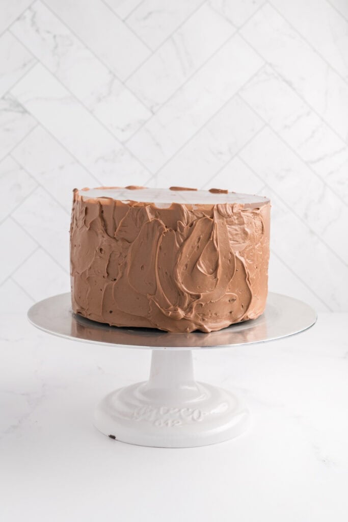 M&M Chocolate Cake covered with chocolate Swiss meringue buttercream with acrylic disc attached.