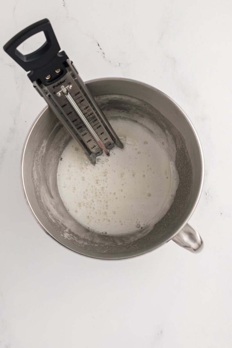 Overhead shot of the cooked egg whites with thermometer for M&M Chocolate Cake.