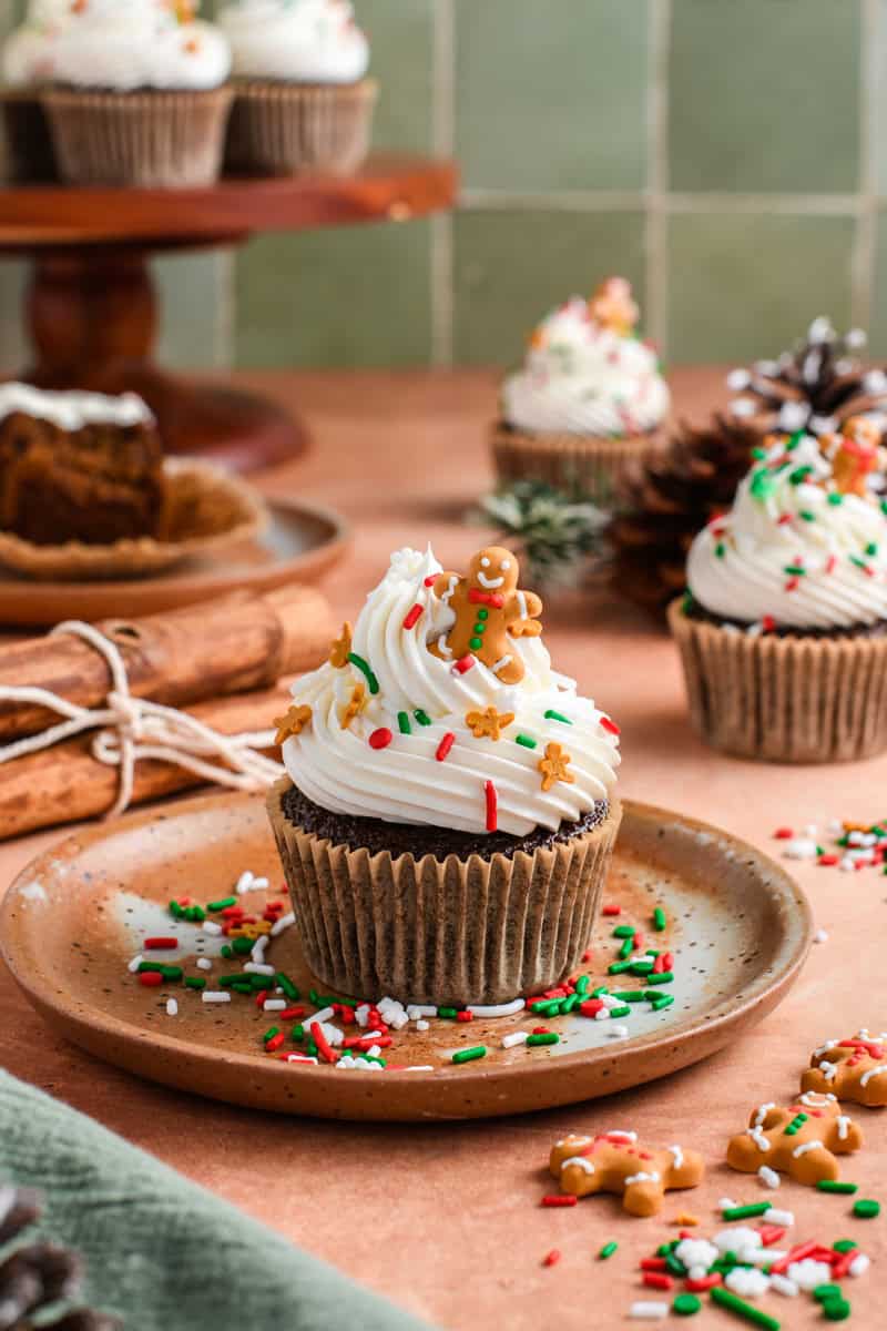 Wide open shot of one Gingerbread Cupcake on please with extra cupcakes in the background.