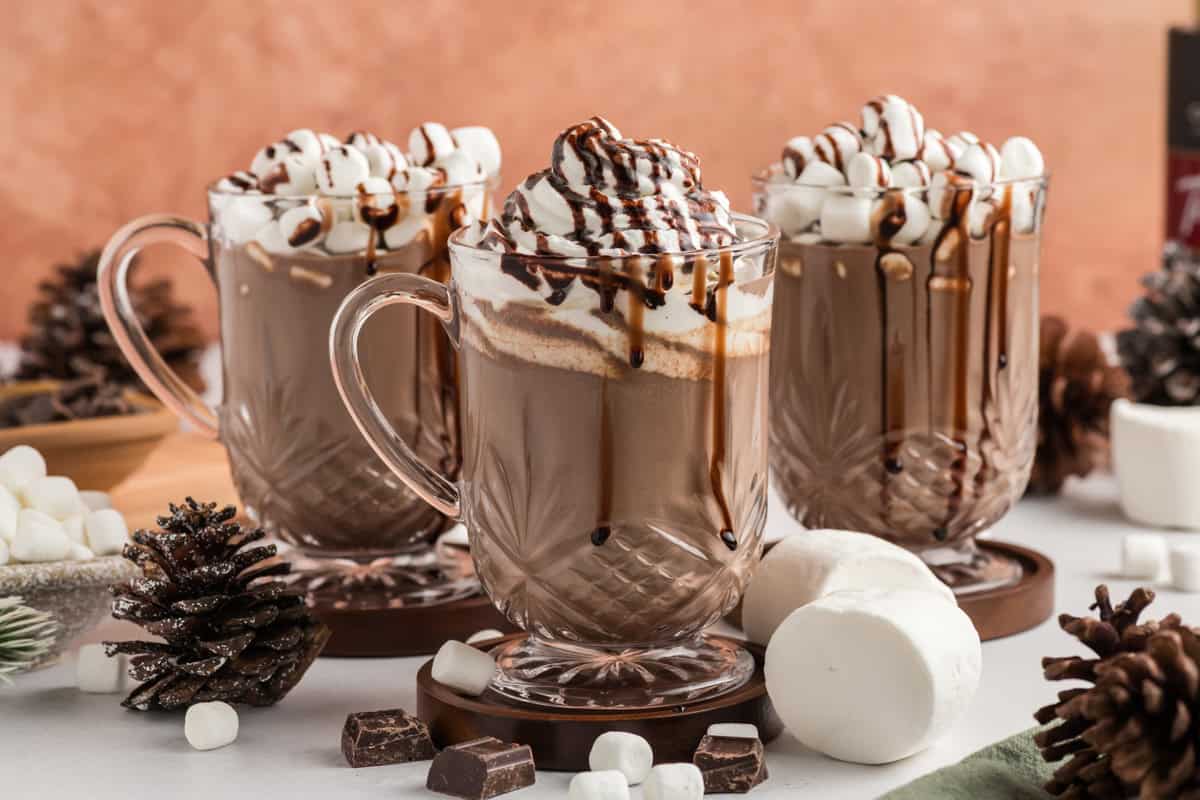 Landscape shot of 3 cups of Slow Cooker Hot Chocolate with garnishes.